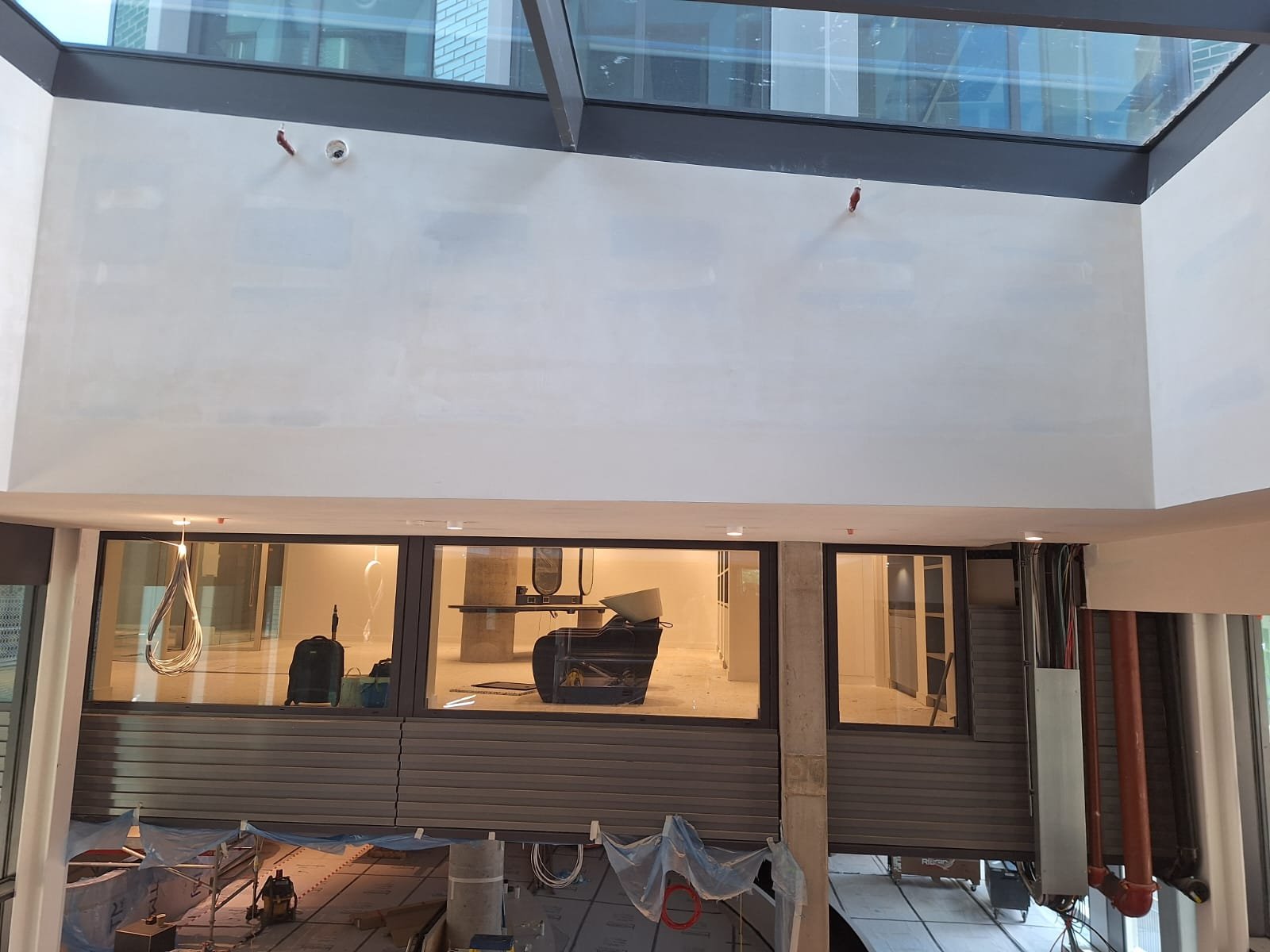 Double-height commercial space with large plasterboard elevations finished flush