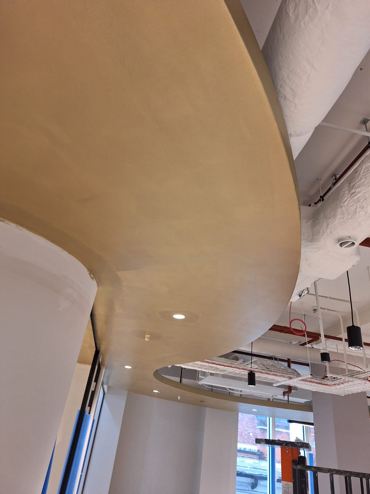 Close view of a curved plasterboard ceiling edge finished with no visible joint line
