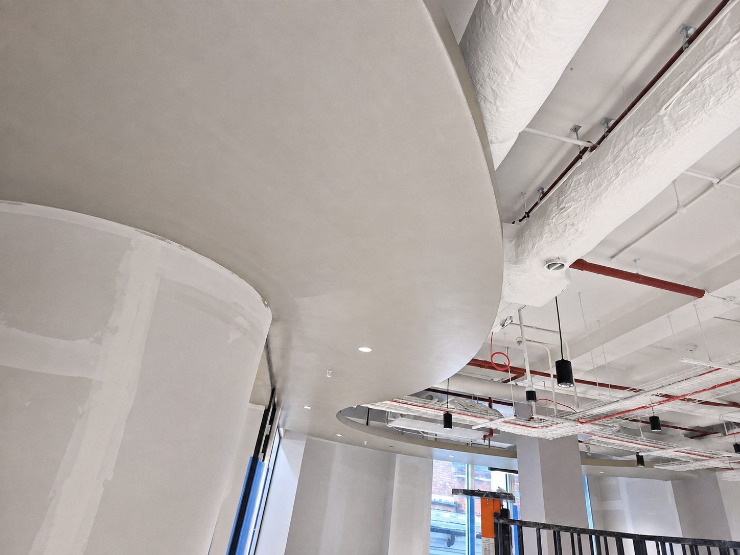 Curved bulkhead ceiling finished flush where it meets a glazed elevation